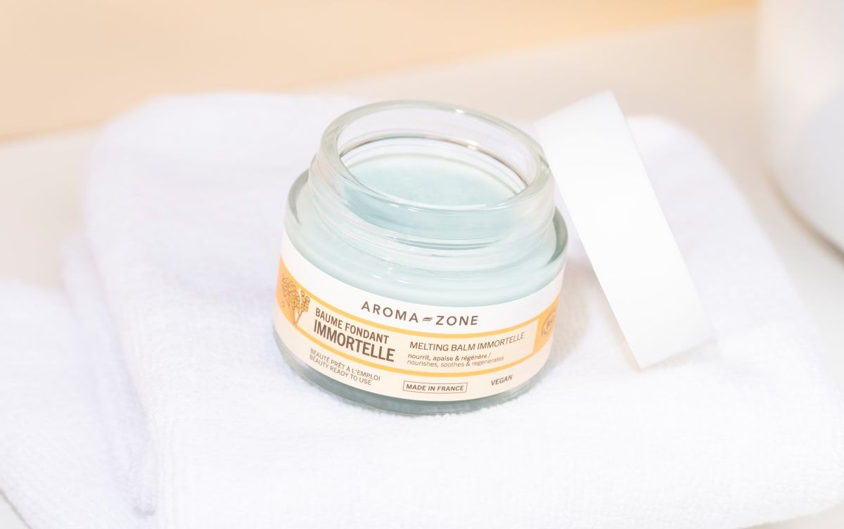 Pot de baume ouvert sur une serviette blanche